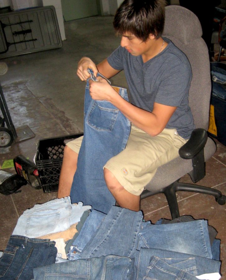 Junior Alex Villapando helps sort jeans for the homeless for Foothill's Teen Voice. Photo by Eva Morales, The Foothill Dragon Press.